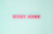 © amaidesign - Words 'stay home' made of pink wooden letters on light turquoise background