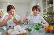 © lordn - Beautiful children painting colorful eggs for easter holidays at home. Easter egg dyeing