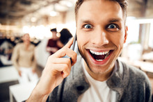 Joyful Young Man With Happy Wide Smile Talking On Cellphone