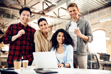 Wall Mural - Joyful business people using laptop in modern office