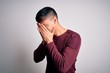 © Krakenimages.com - Young handsome hispanic man wearing casual shirt standing over white isolated background with sad expression covering face with hands while crying. Depression concept.