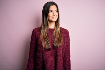 Poster - Young beautiful girl wearing casual sweater over isolated pink background smiling looking to the side and staring away thinking.