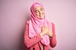 © Krakenimages.com - Young beautiful girl wearing muslim hijab standing over isolated pink background smiling with hands on chest with closed eyes and grateful gesture on face. Health concept.