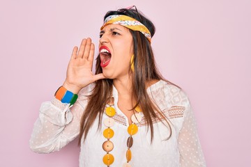 Sticker - Young hispanic hippie woman wearing fashion boho style and sunglasses over pink background shouting and screaming loud to side with hand on mouth. Communication concept.