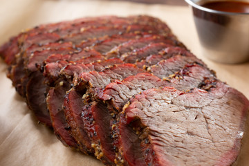 A closeup view of a tray of barbecue tri tip meat slices, in a restaurant or kitchen setting.