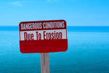 Warning Sign At The Beach In Michigan USA, As Global Warming And High Waters From Lake Michigan Wash Away Beaches