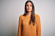 © Krakenimages.com - Young beautiful brunette woman wearing casual sweater over isolated white background Relaxed with serious expression on face. Simple and natural looking at the camera.