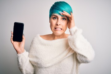 Sticker - Young woman with blue fashion hair holding smartphone showing screen stressed with hand on head, shocked with shame and surprise face, angry and frustrated. Fear and upset for mistake.