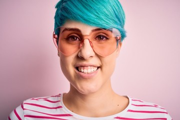 Sticker - Young beautiful woman with blue fashion hair wearing fanny glasses with hearts with a happy face standing and smiling with a confident smile showing teeth