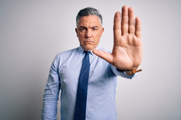 Poster - Middle age handsome grey-haired business man wearing elegant shirt and tie doing stop sing with palm of the hand. Warning expression with negative and serious gesture on the face.