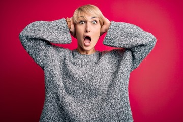 Sticker - Young blonde woman with modern short hair wearing casual sweater over pink background Crazy and scared with hands on head, afraid and surprised of shock with open mouth