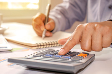 Close-up of women using calculators and note-taking, accounting reports, cost-calculation ideas and saving money.