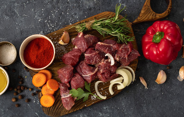 Canvas Print - Сut of meat with vegetable on a dark background top view