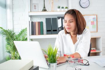 Poster - A young office worker working in a laptop at home