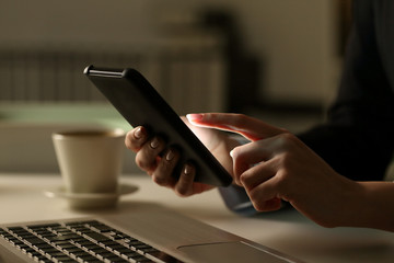 Executive woman hands using phone at night in the office