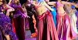 Women dance oriental dances in colored dresses
