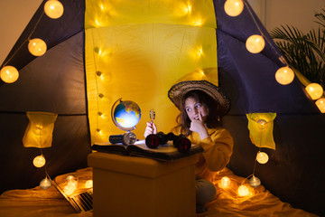 Wall Mural - little girl playing acoustic guitar under the tent in a living room.