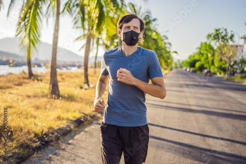 Runner wearing medical mask, Coronavirus pandemic Covid-19. Sport, Active life in quarantine surgical sterilizing face mask protection. Outdoor run on athletics track in Corona Outbreak. Keep your
