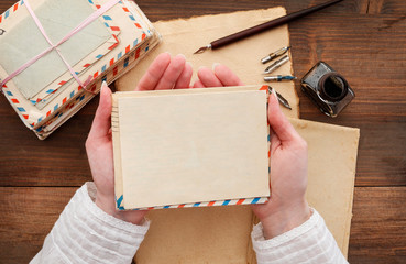 Young woman holds an envelope and blank sheet of paper