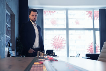 Wall Mural - Businessman looking at map of coronavirus pandemic and economy and financial markets collapse by corona virus. Staying at office. Illustration of covid pandemic panic and unemployment crisis.