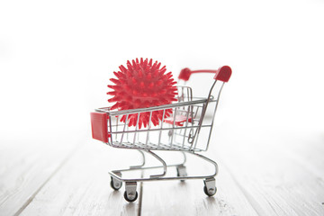 Impact of coronavirus COVID-19 on the global economy, Abstract virus strain red model of Coronavirus disease COVID-19 in a shopping cart on wooden table. Financial crisis 2020.