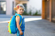 © Irina Schmidt - Cute little adorable toddler girl on her first day going to playschool. Healthy beautiful baby walking to nursery school and kindergarten. Happy child with backpack on the city street, outdoors.