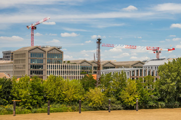 Wall Mural - Bacalan district in Bordeaux France with white and red cranes above dwellings and buildings seem from the other bank of the Garonne River