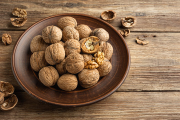 Wall Mural - Nuts. Walnut kernels and whole walnuts on wooden table.