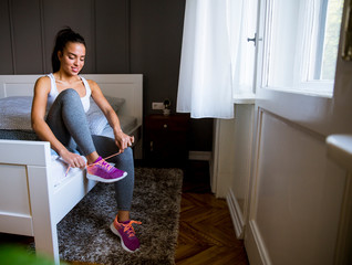 Young attractive woman preparing for exercises at home