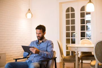 Wall Mural - Young man working from home on digital tablet