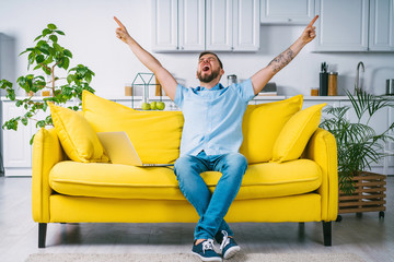 Attractive bearded man celebrating victory in online casino, guy supporting favourite soccer team cheering for goal