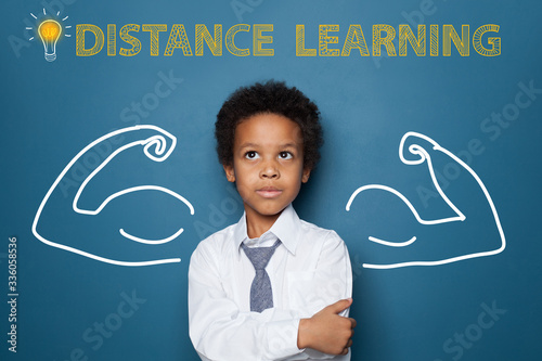 Fotografía Distance learning concept with clever black kid on blackboard background