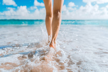 legs of a beautiful young girl who runs towards the ocean on a sandy beach. vacation on the paradise