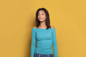 Wall Mural - Beautiful black brunette on yellow background, studio portrait