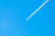 © Ronald Rampsch - Ein Flugzeug mit Kondensstreifen am blauem Himmel