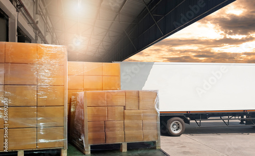 Interior of warehouse, Large pallet shipment boxes, Truck docking load cargo at warehouse, Road freight industry logistics shipping and transport