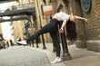 young woman doing a back bend in the street