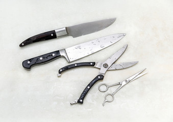 Set of two kitchen knives and scissors wet from water after cleaning, isolated on a white background closeup