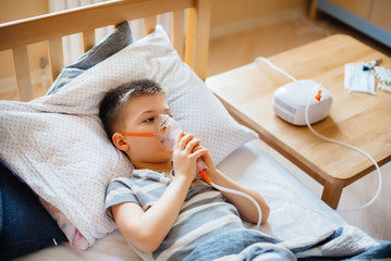 A young boy is given an inhalation during a lung disease. Medicine and care