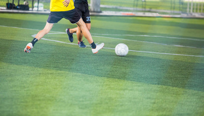 Selective focus to soccer player speed run to control and shoot ball to goal. Soccer players fighting each other by kicking the ball.