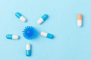 Pills isolated on blue background.Colorful medical drug capsule. Concept of coronavirus