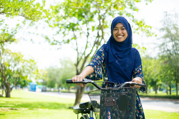 Muslim woman holding bicycle