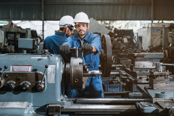 Wall Mural - Engineer men wearing uniform safety workers perform maintenance in factory working machine lathe metal.