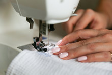 Woman's Hands Sew On A Sewing Machine Close Up