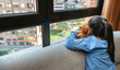 © David Pereiras - Unrecognizable girl looking out the window sad because she can't get out
