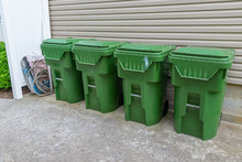 Four Plastic Trash Cans With Other Garbage