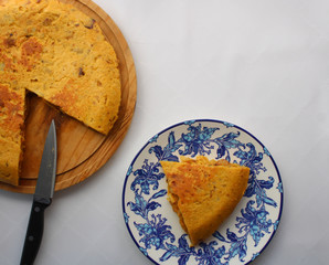 Poster - Spanish potato omelette next to a serving piece. Top View. Whole potato omelette on top of a wooden board. 