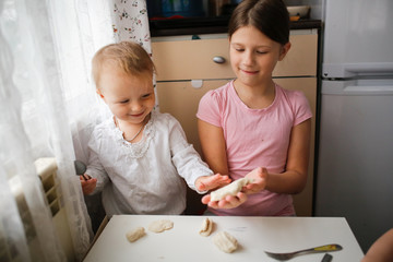 Wall Mural - Children make the dough. Daughters help mom