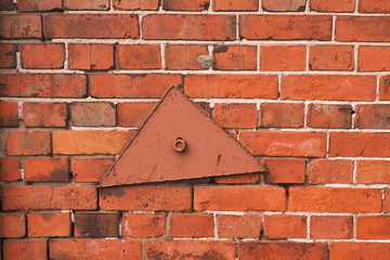 Wall Mural - Red brick wall and a large triangular washer. Strengthening the wall. Reinforcement of the wall.