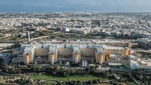 Aerial Shot Of Mater Dei Hospital In Malta Surrounded By Other Buildings